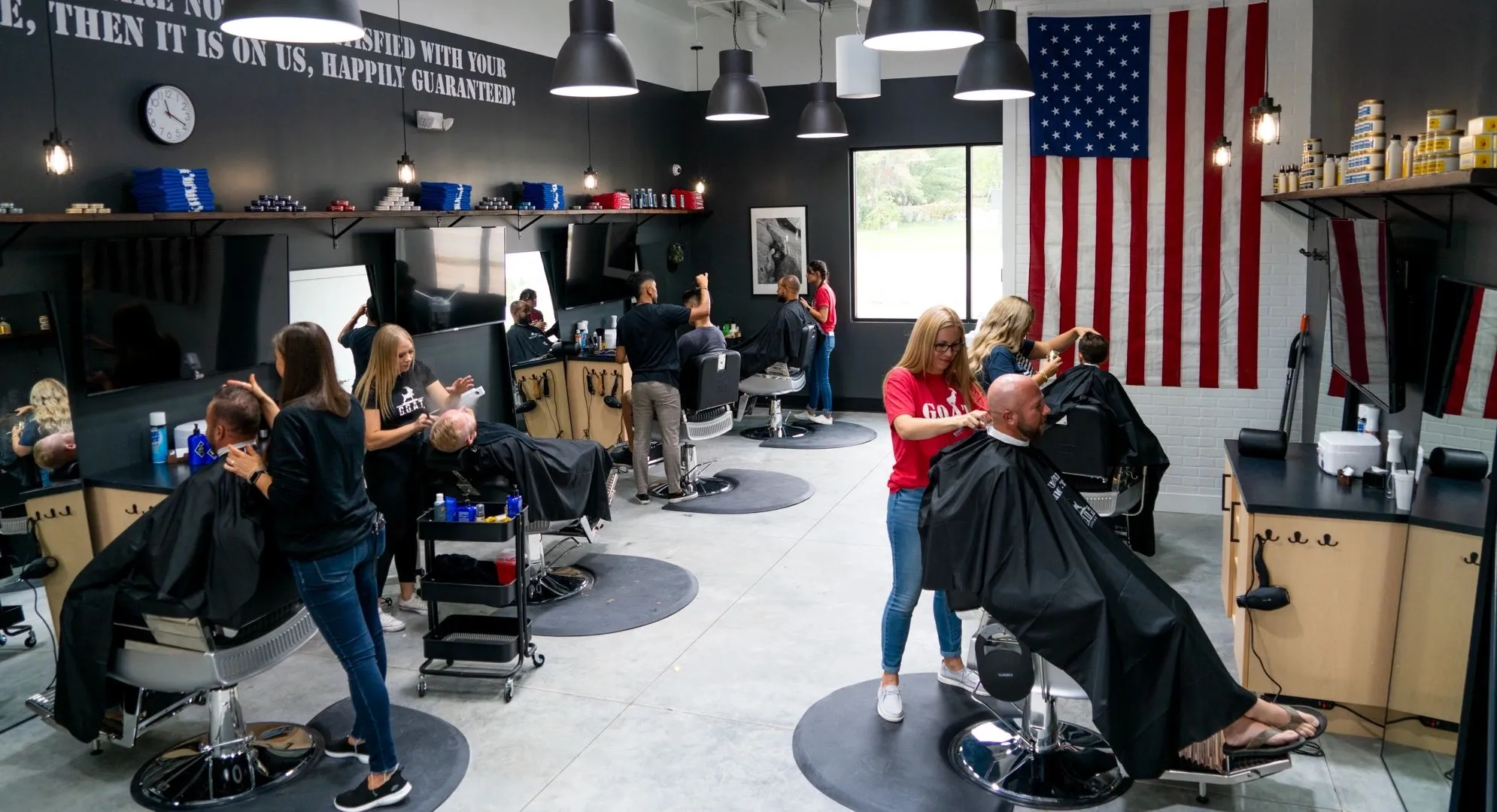 Barbers cutting hair on a busy day at G.O.A.T. Haircuts